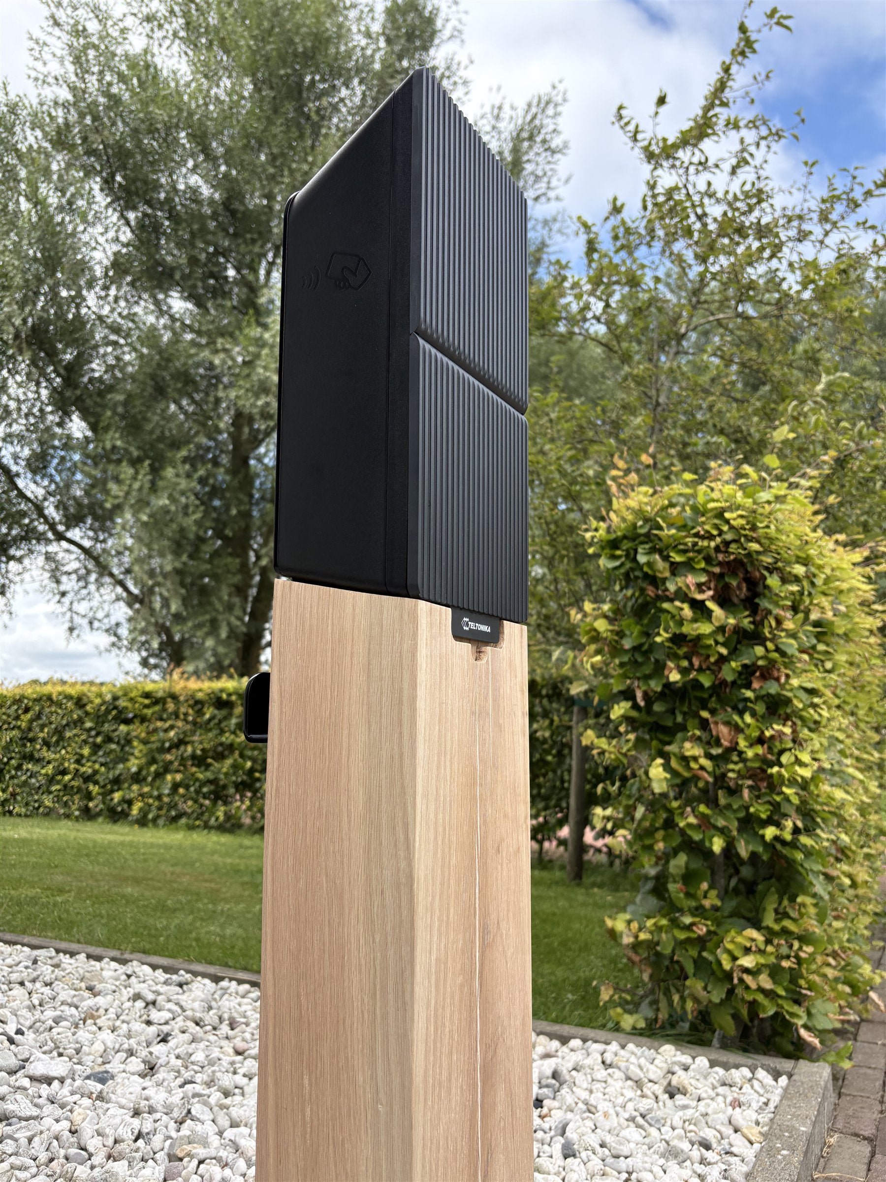 Houten laadpaal in een groene tuin